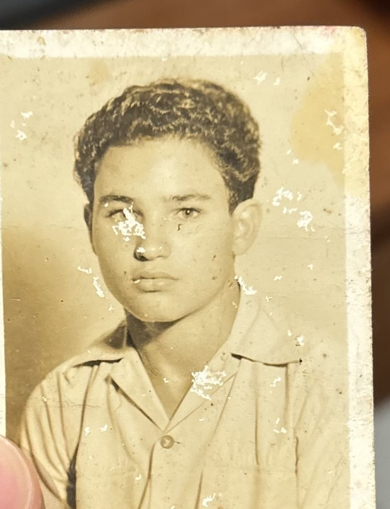 The same young man's portrait before restoration, faded and damaged